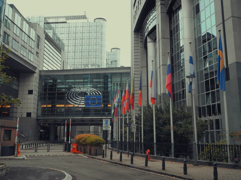 Facade of the European Parliament in Brussels with EU flags