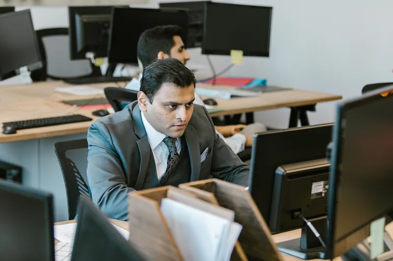 A man in a suit working at a desk in natural light